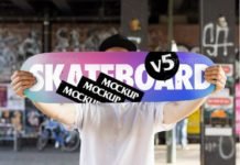 Hand holding Skateboard Mockup