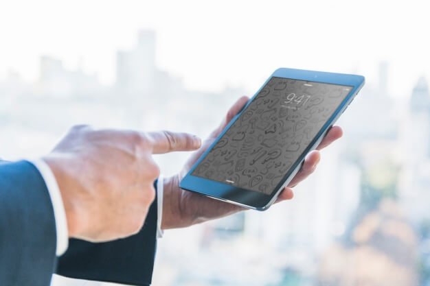Businessman Holding iPad in front of a skyline