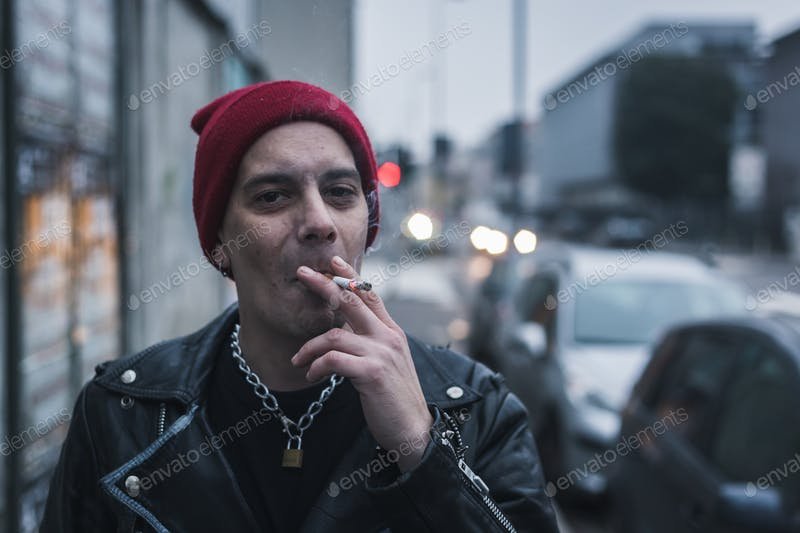 A Guy Wearing Beanie Smoking Cigarette In The Street