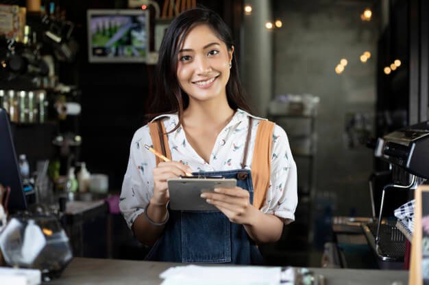Asian Women Wearing Apron Smiling In A Coffee Shop Mockup