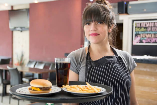 Female Waitress Holding Food In An Apron