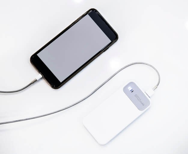 Smartphone being charged using a power bank Premium Psd
