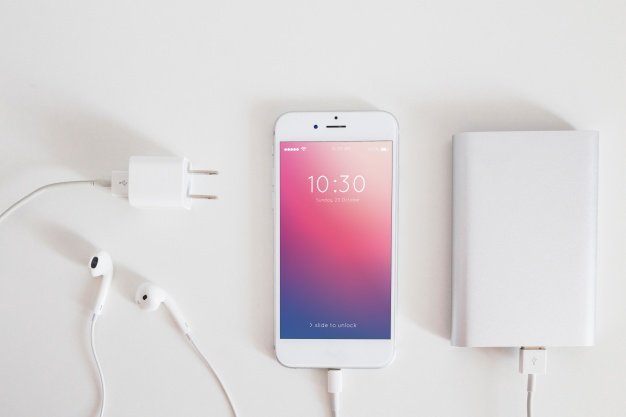 Smartphone mockup with charging cable and earphones Free Psd