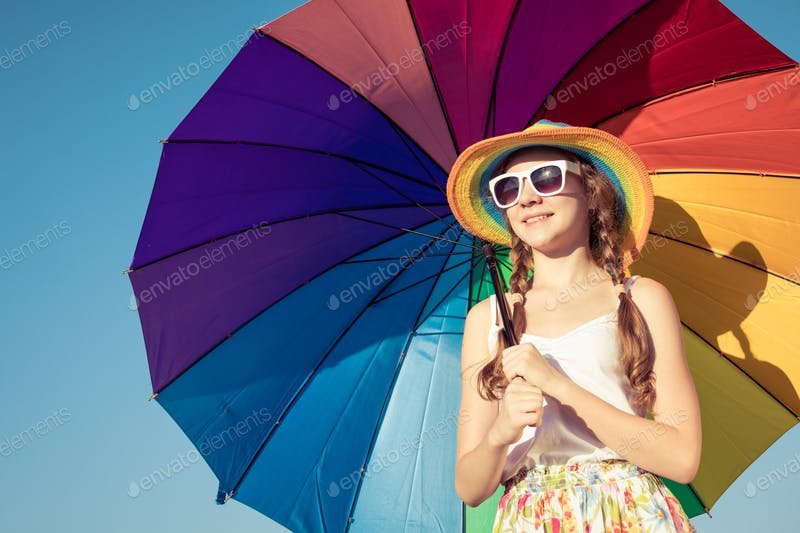 A Teen Girl  Standing On a beach Holding A Colorful Umbrella PSD Template.
