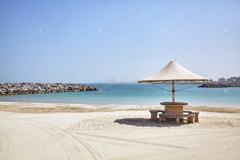 A White Umbrella In An empty Beach PSD Template.