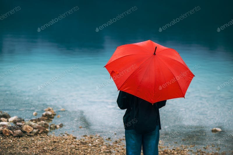 A Woman Holding A Red Umbrella Near A Lake PSD Template.