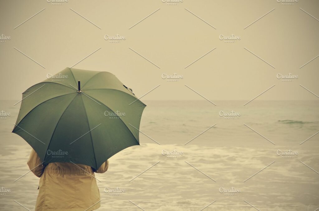 A Woman Holding Green Umbrella Near A Sea PSD Template.