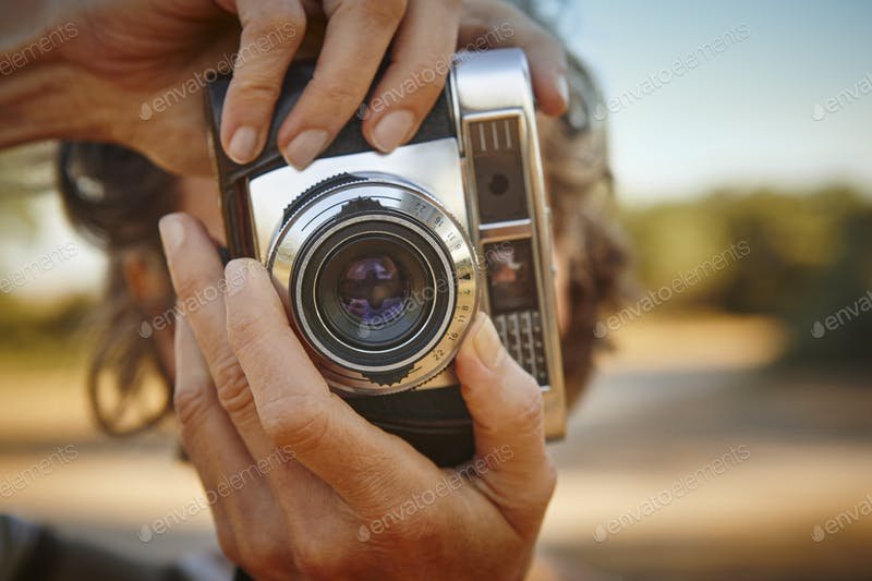 A Woman Taking Photos With A Vintage Camera PSD Mockup. 