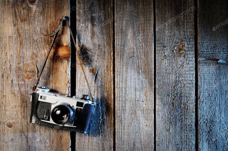 An Old Camera Hanging On The Wooden Wall PSD Mockup. 
