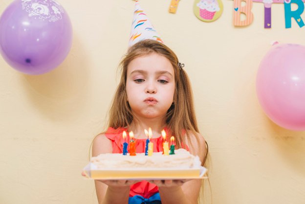Birthday Girl holding Cake with Candles Photo