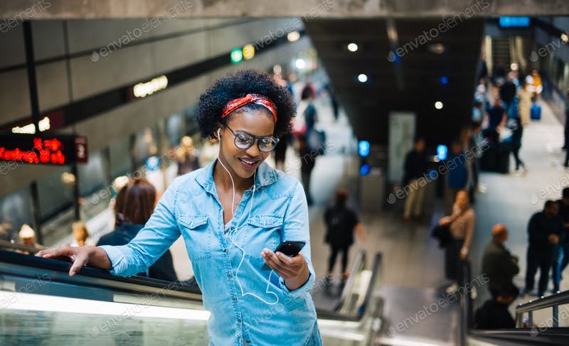 Young Girl On Metro Escalator Using Smart Phone
