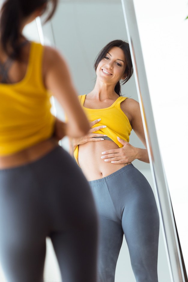 Beautiful Young Woman In Yellow Tank Top Looking At The Mirror PSD