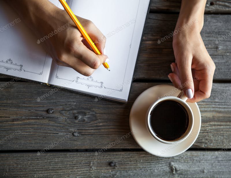 Female Hand Taking Notes With a cup of Coffee Mockup. 