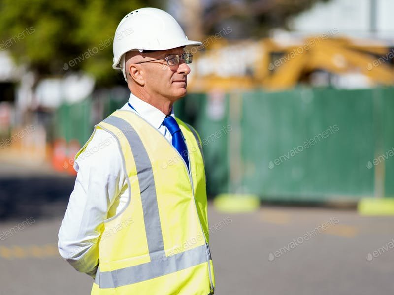 Old Builder At Construction Site In Yellow Safety Vest PSD.