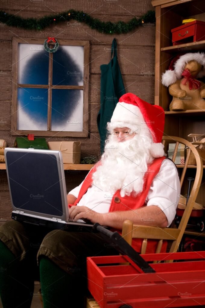 Santa In Workshop Using His Laptop Mockup. 