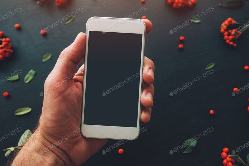 Smart phone in a man's hand PSD Mockup. 