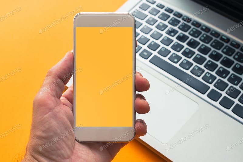Smartphone in hand with yellow screen Mockup.