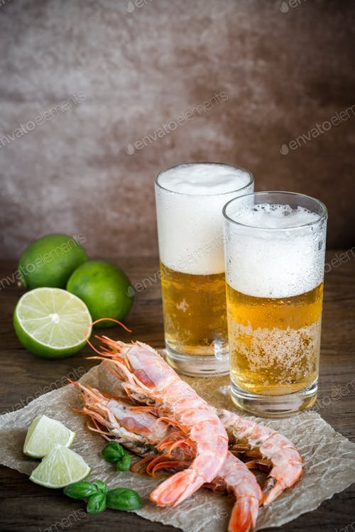 Two Lager Glass Of Beer With Shrimps And Lemon Placed On A Table PSD