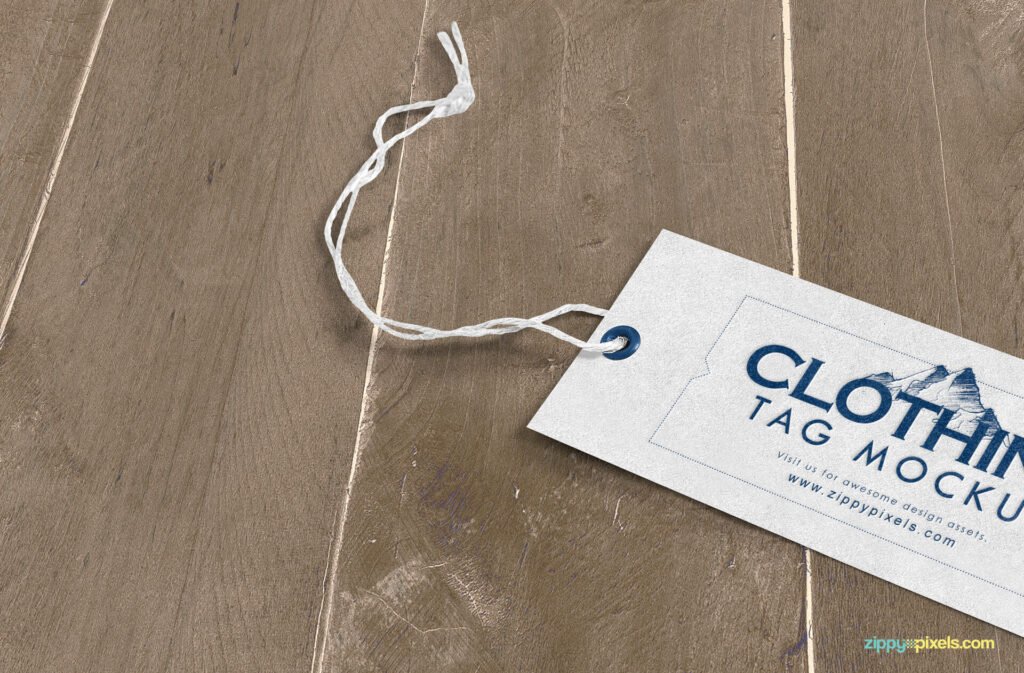 White Hang Tag Kept On Wooden Table Mockup