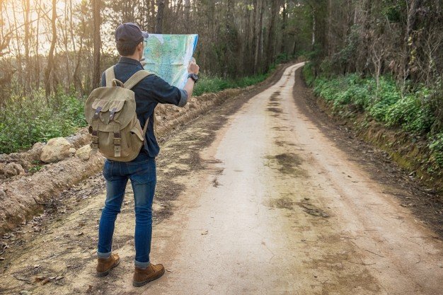 Traveller carrying a backpack with map in hand Mockup