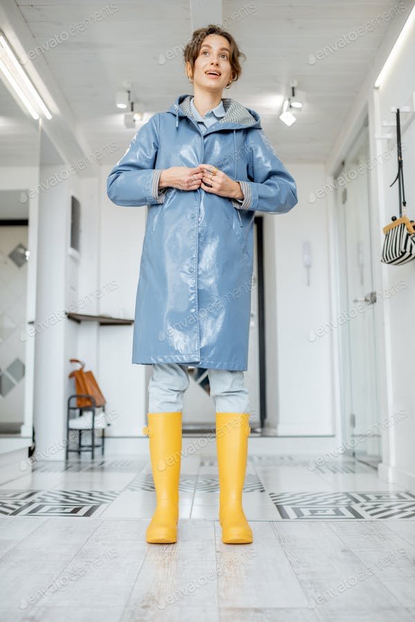 Woman wearing yellow boots and raincoat at the hallway