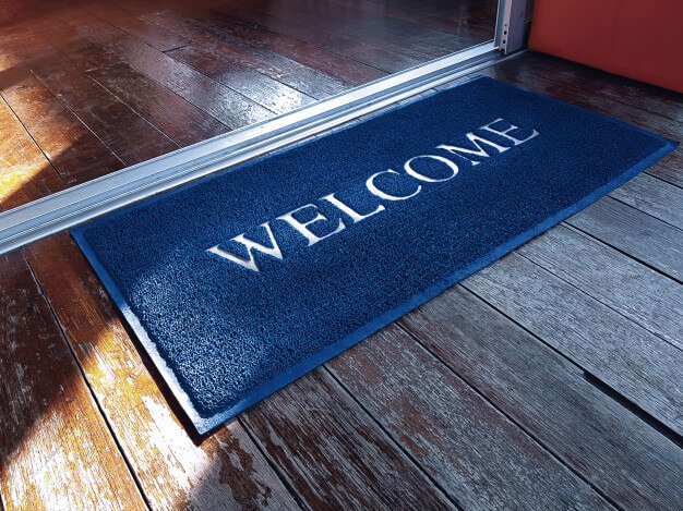 Blue doormat with welcome text in front of shop Premium Photo (1)