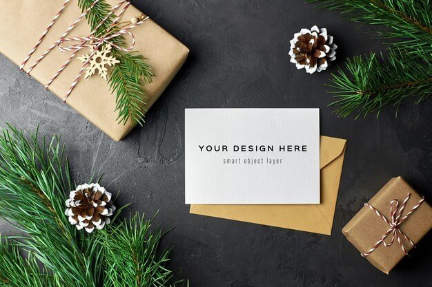 Greeting card mockup with christmas gift boxes and pine branches and cones Premium Psd